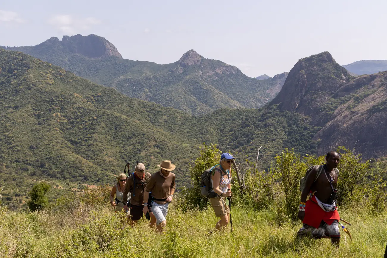 Guests walking with Samburu guides through the hills of northern Kenya